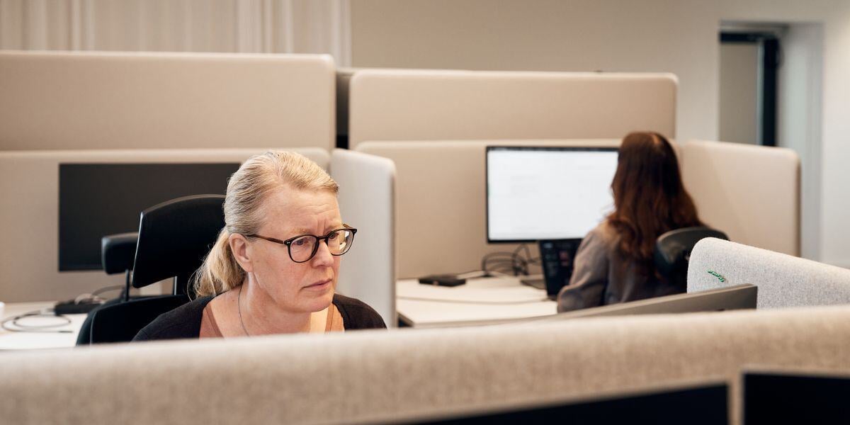 Two women working at their computers in an open-plan office